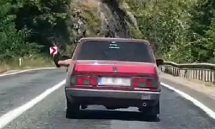 Ayaklarını camdan sarkıtarak trafiği tehlikeye attı