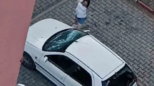 Park halindeki otomobilin camlarını kıran kadın kamerada