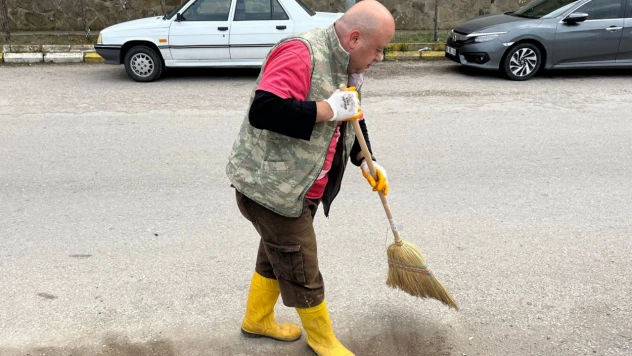 Sevabına mahalleyi temizliyor